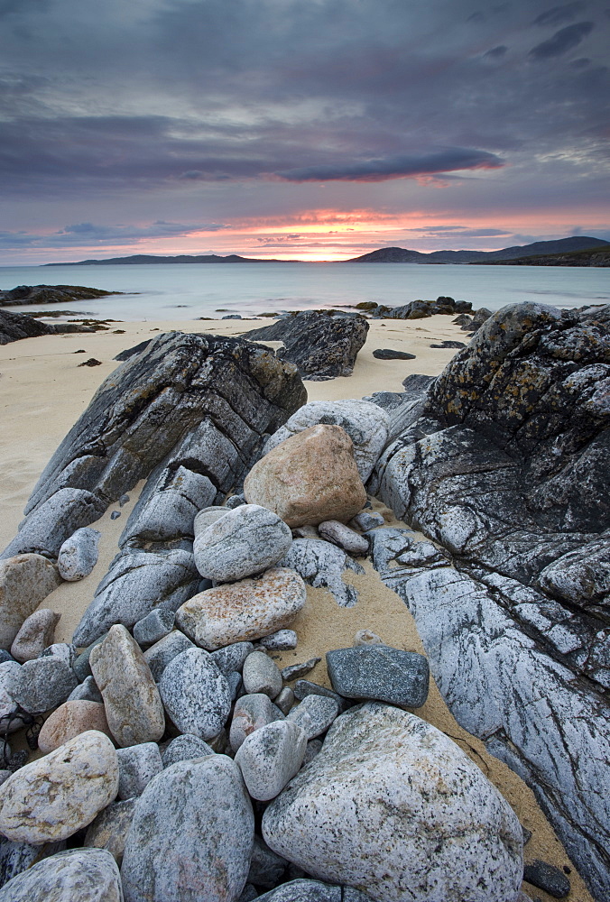 View towards Taransay at sunset from the rocky shore at Scarista, Isle of Harris, Outer Hebrides, Scotland, United Kingdom, Europe