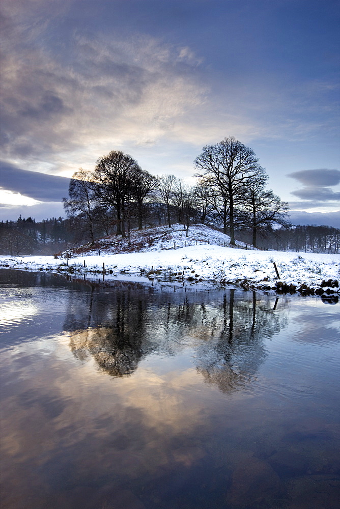 Winter view of River Brathay at dawn, under snow with reflections, near Elterwater Village, Ambleside, Lake District National Park, Cumbria, England, United Kingdom, Europe