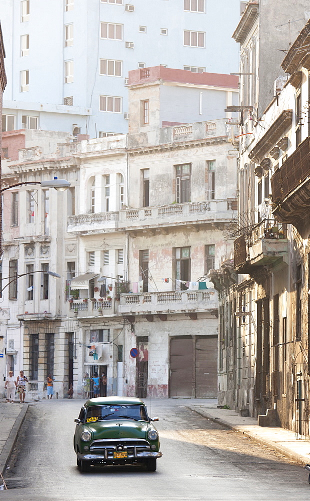 Classic American car taxi driving down quiet street in Havana Centro, Havana, Cuba, West Indies, Central America