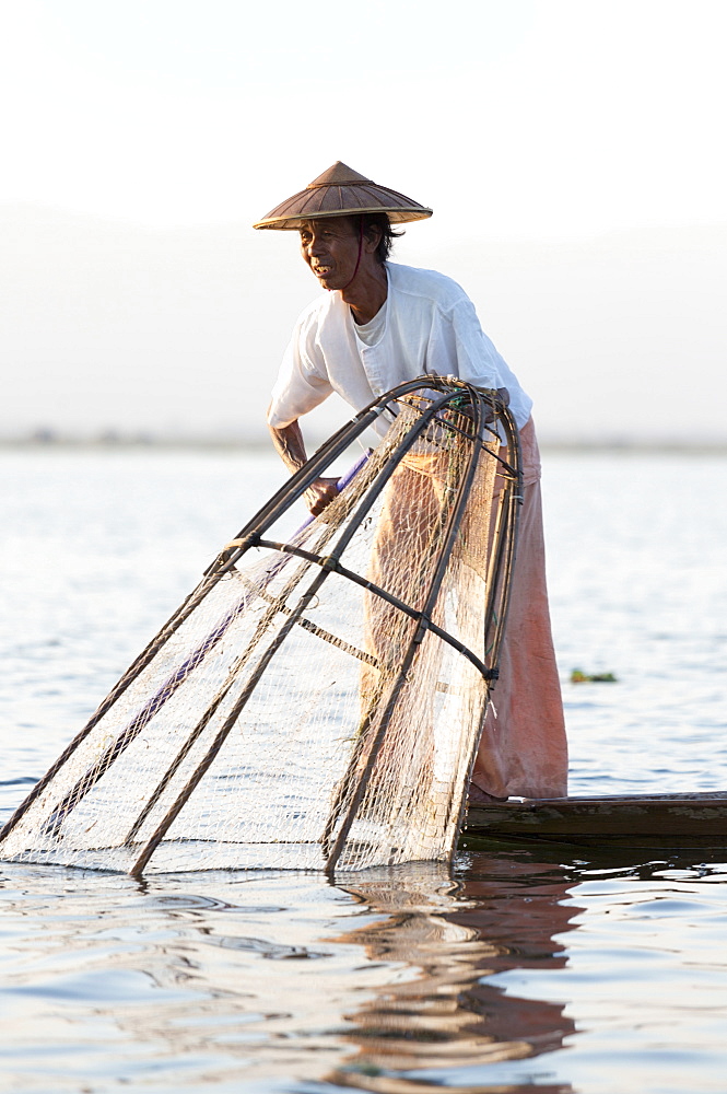 Intha leg rowing fishermen on Inle Lake who row traditional wooden boats using their leg and fish using nets stretched over conical bamboo frames, Inle Lake, Shan State, Myanmar (Burma), Asia