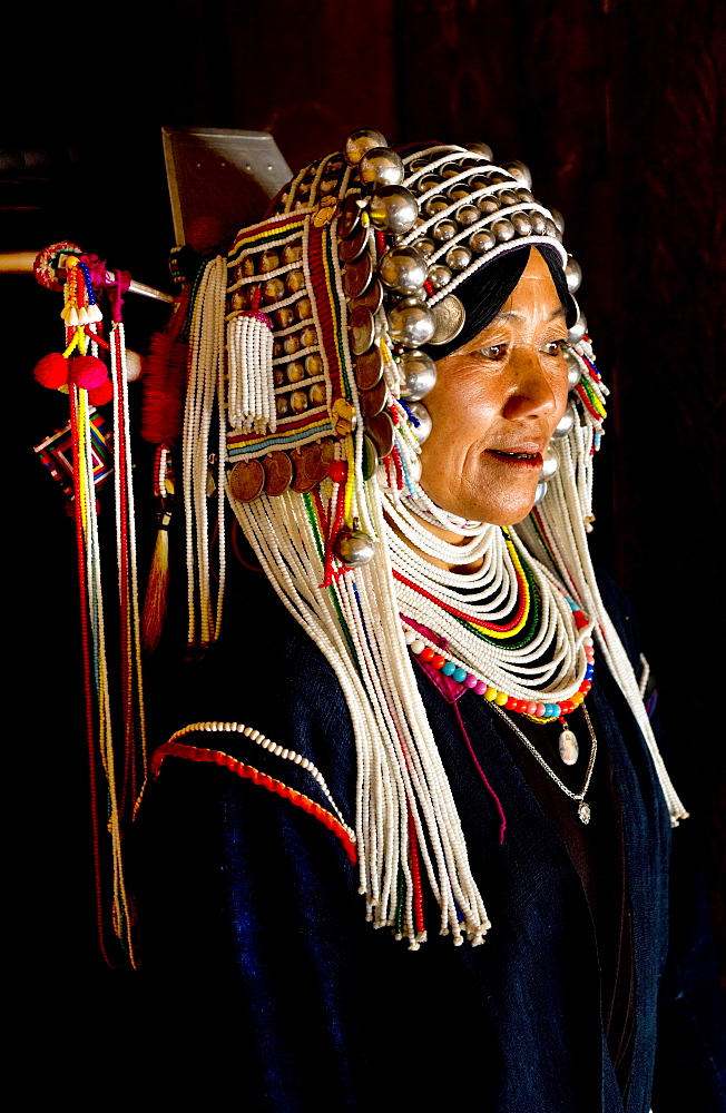 Woman of the Akha tribe in traditional dress including a headdress of heavy silver baubles, in a hill village near Kengtung (Kyaingtong), Shan State, Myanmar (Burma), Asia