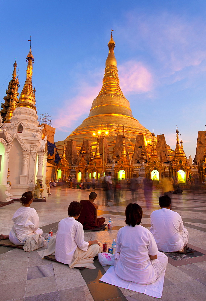 Shwedagon Paya (Pagoda) at dusk with Buddhist worshippers praying, Yangon (Rangoon), Myanmar (Burma), Asia