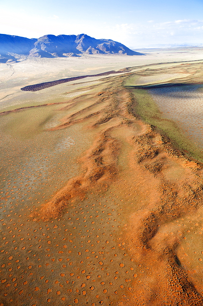 Aerial view from hot air balloon over magnificent desert landscape of sand dunes, mountains and Fairy Circles, Namib Rand game reserve Namib Naukluft Park, Namibia, Africa