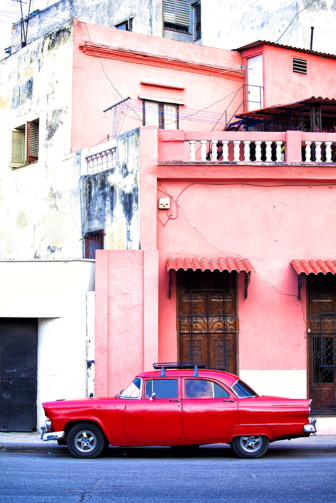 Red vintage American car parked on a street in Havana Centro, Havana, Cuba, West Indies, Central America