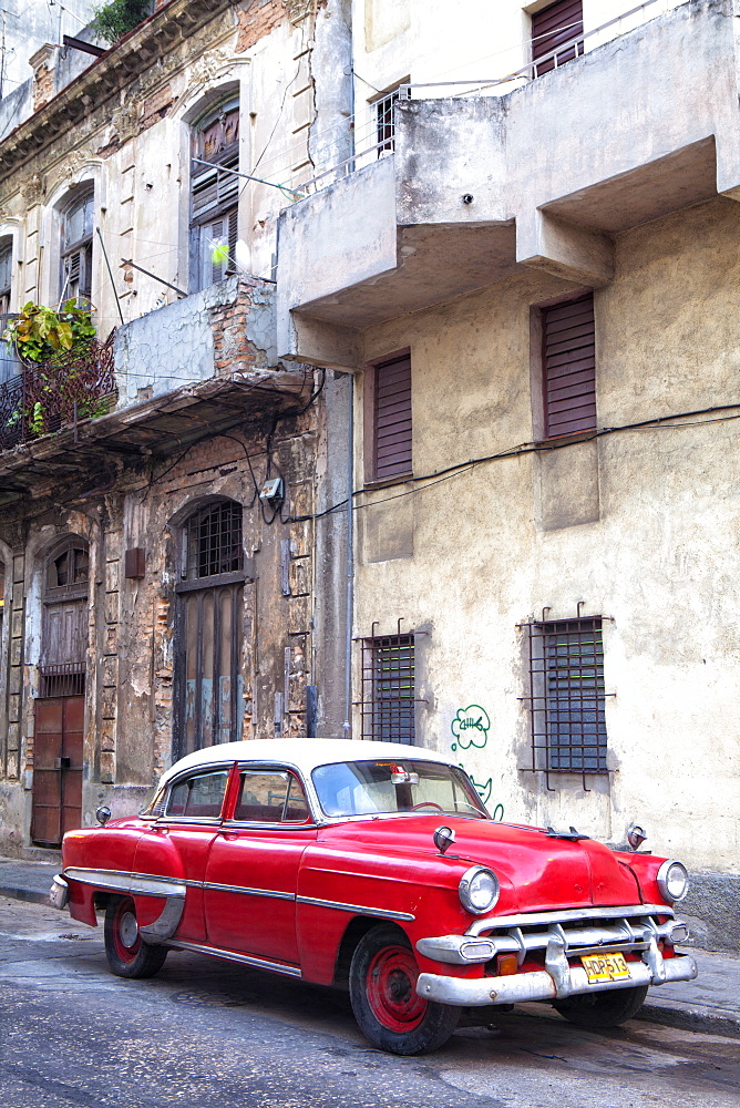 Red vintage American car parked on a street in Havana Centro, Havana, Cuba, West Indies, Central America