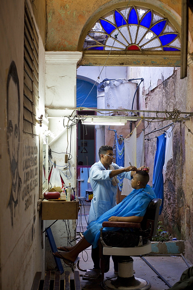 Man having haircut in backstreet barber shop, Havana Viejo, Havana, Cuba, West Indies, Central America 