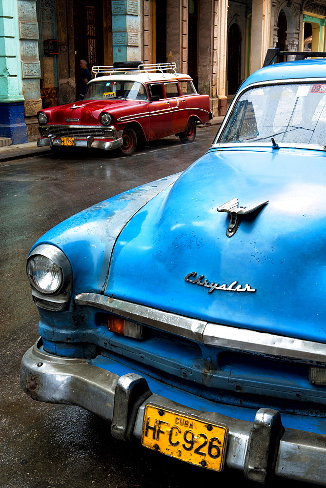 Vintage American cars parked on a street during early morning rainfall, Havana, Cuba, West Indies, Central America