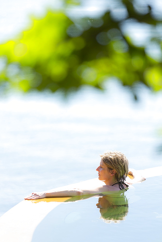 Woman in an infinity pool looking out to sea, Koh Samui, Thailand, Southeast Asia, Asia