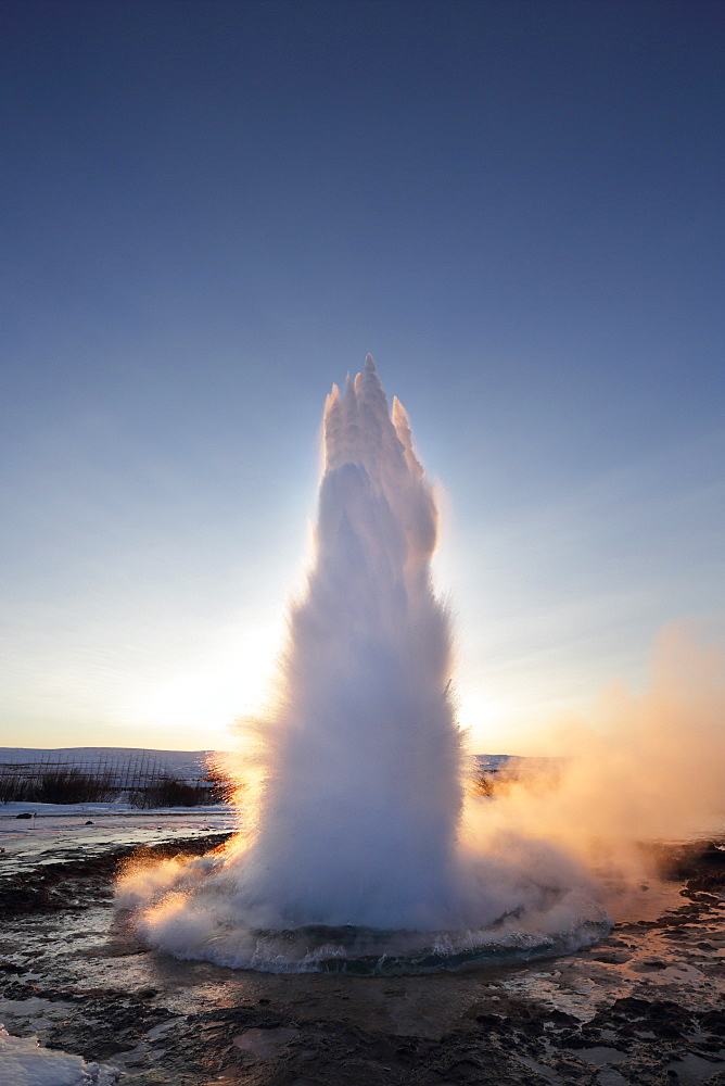 Strokkur Geysir erupting at sunrise during winter, geothermal area beside the Hvita River, Geysir, Iceland, Polar Regions