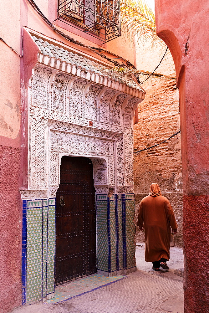 Local man dressed in traditional djellaba walking through street in the Kasbah, Marrakech, Morocco, North Africa, Africa