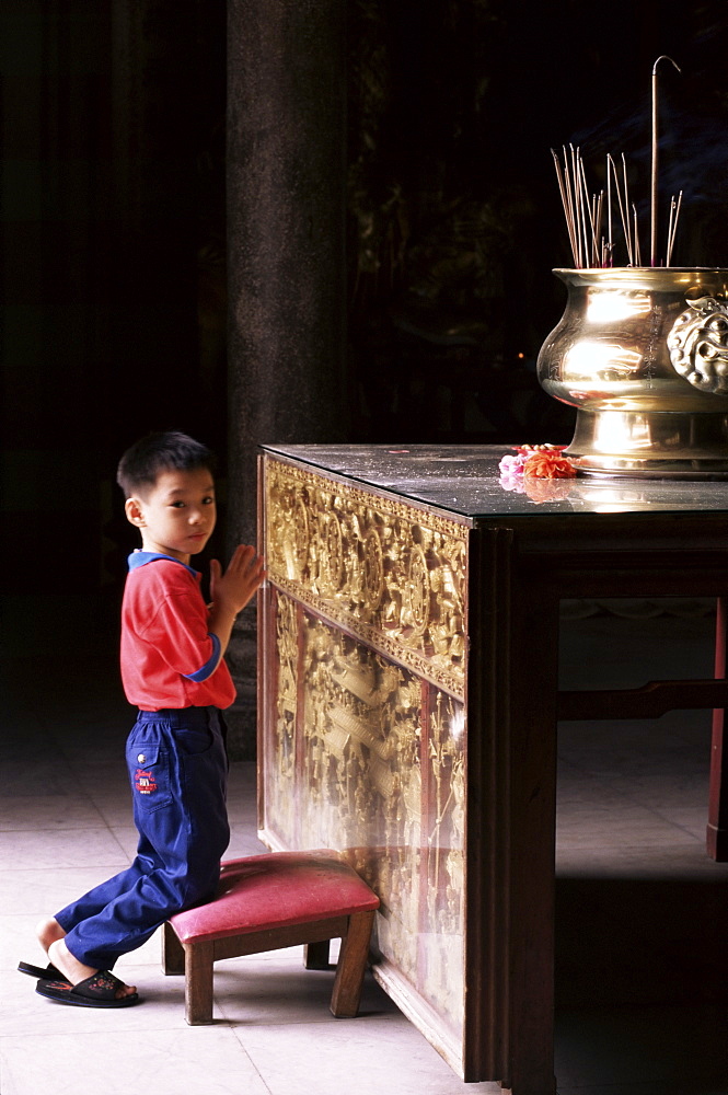 Boy worshipping, Kek Lok Si temple, Air Itam, Penang, Malaysia, Southeast Asia, Asia