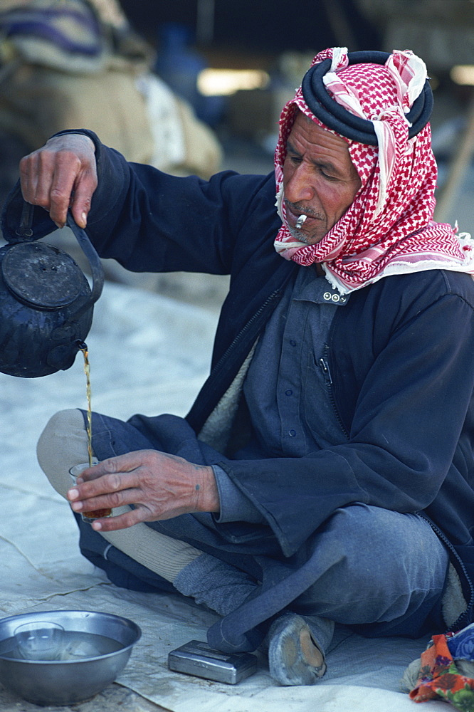 Bedouin man smoking a cigarette, preparing tea, Syria, Middle East