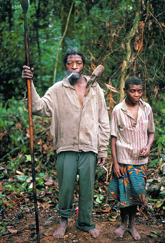 Pygmy man posing with his wife and hunting spear, southeast area, Cameroon, Africa