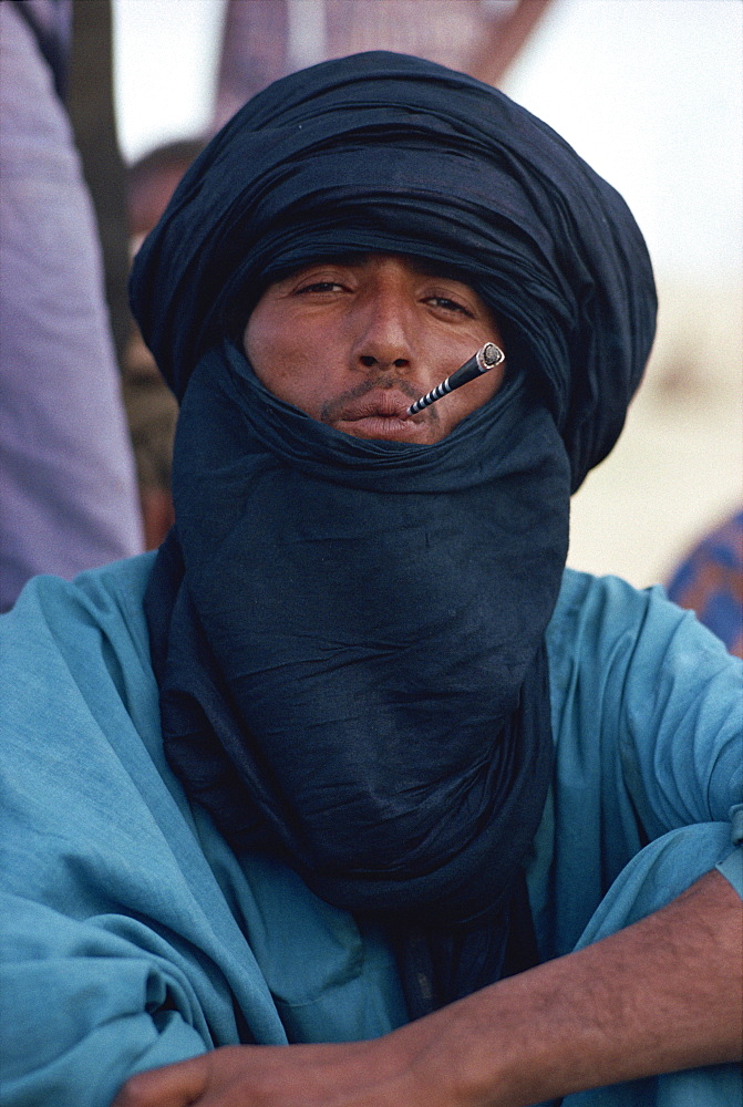 Young Tuareg man smoking small pipe and wearing headscarf, Timbuktu, Mali, West Africa, Africa