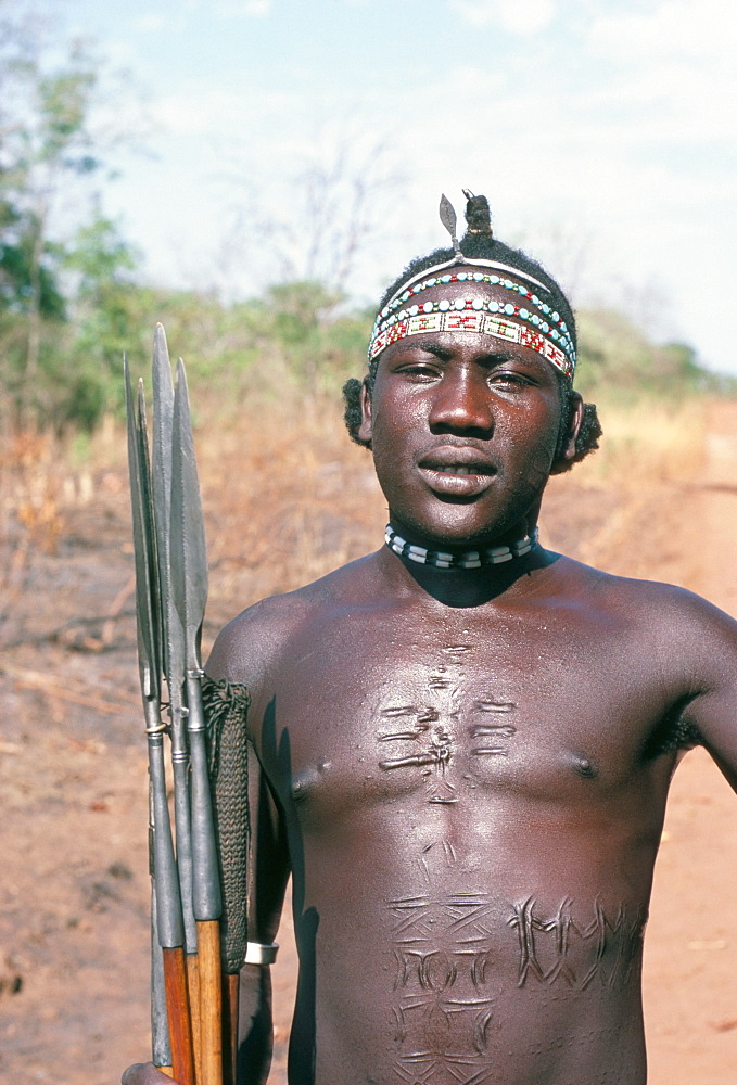 Portrait of a man with spears and elaborate scarring, Azende, Sudan, Africa