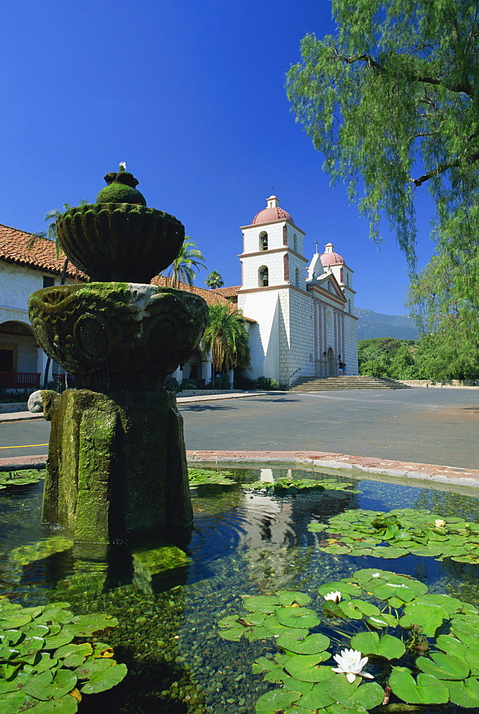 Fountain with water lilies, and The Mission buildings in the background, at Santa Barbara, California, United States of America, North America