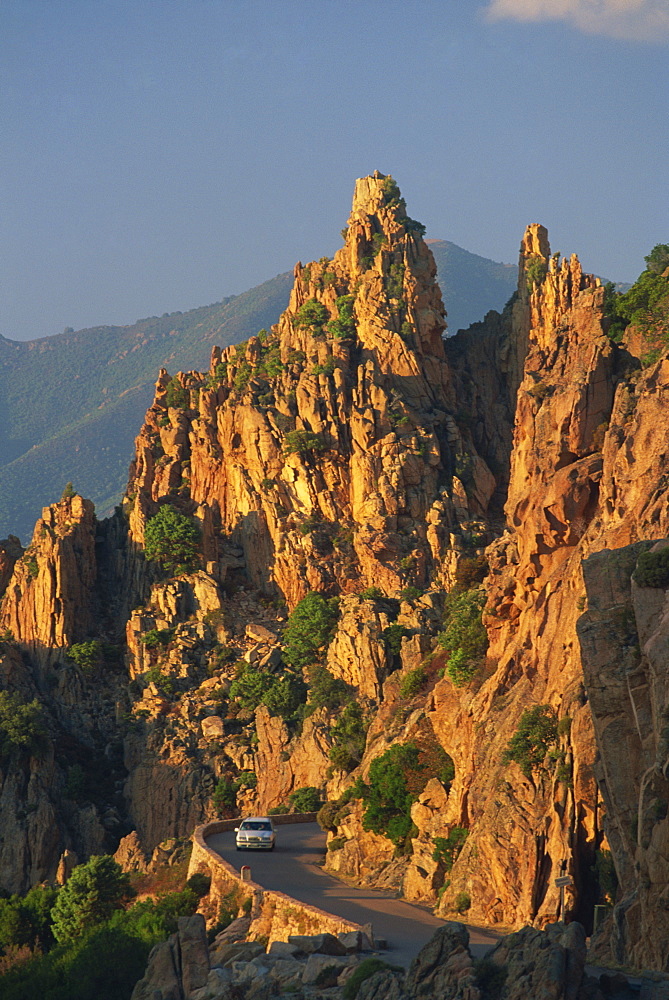 The Calanche, white granite rocks, with car on road below, near Piana, Corsica, France, Europe