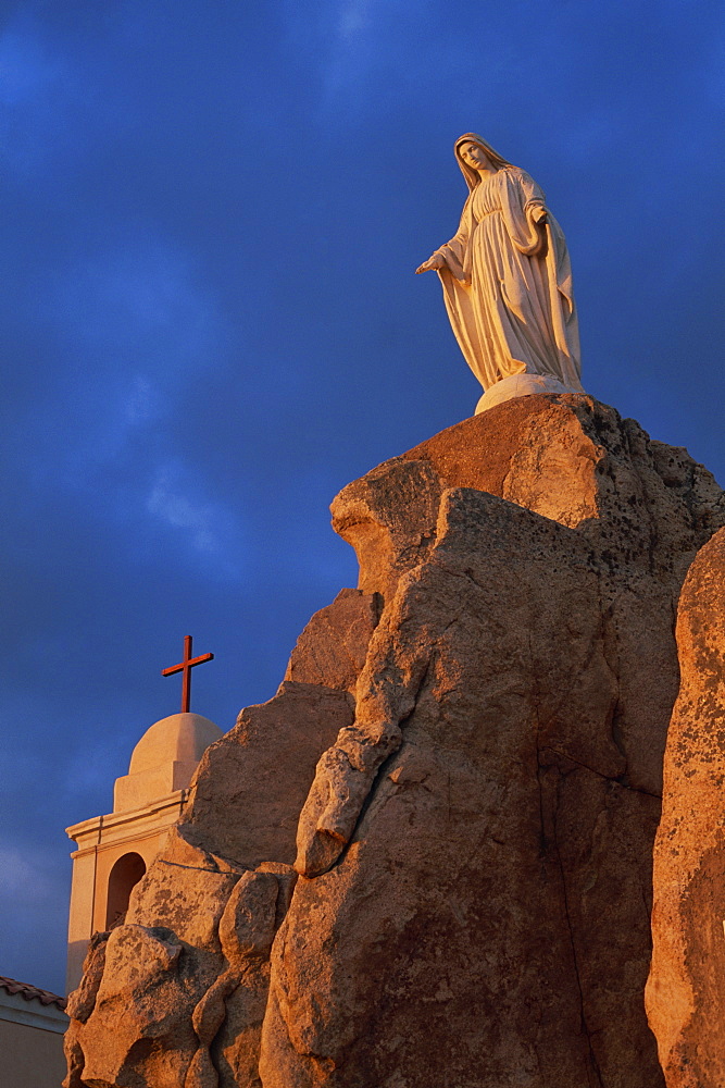 Dawn light on statue of the Virgin and the Chapel of Notre Dame de la Serra, near Calvi, Balagne region, Corsica, France, Europe