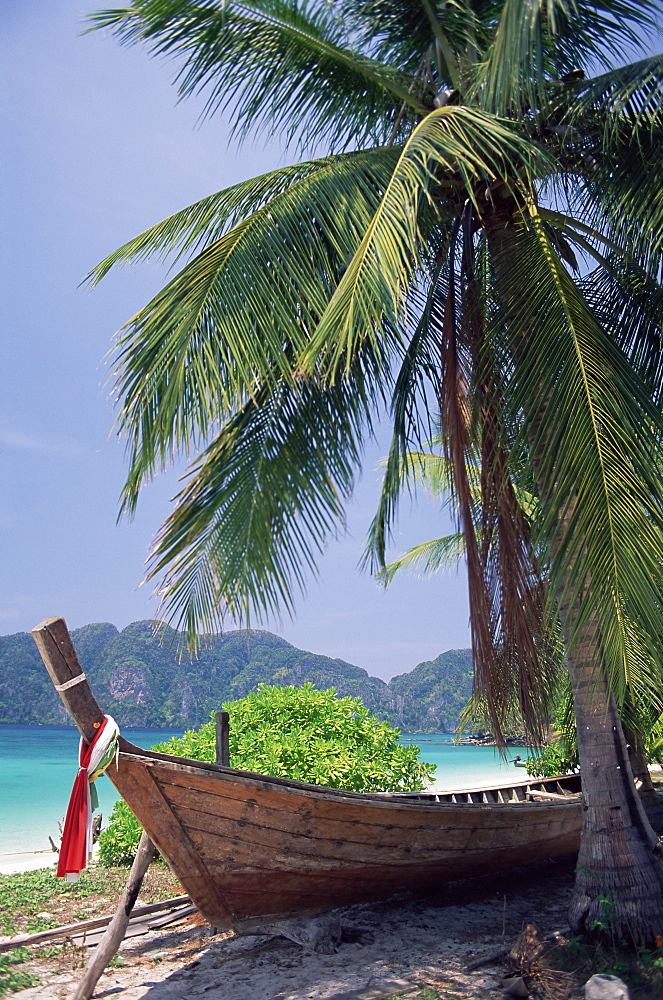 Wooden boat beneath palm trees on beach, Hin Phae Bay, Ko Phi Phi Don, off the island of Phuket, Thailand, Southeast Asia, Asia