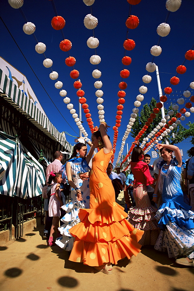 Girls dancing a sevillana beneath colourful lanterns, Feria de Abril (April Fair), Seville, Andalucia (Andalusia), Spain, Europe