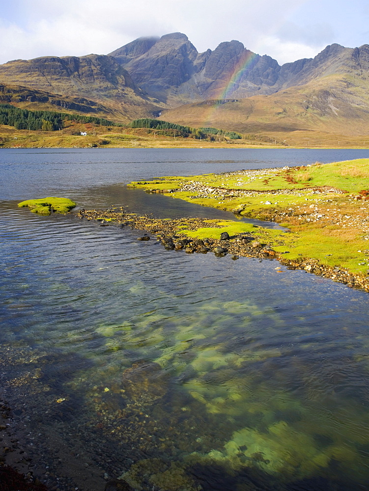 View across the clear waters of Loch Slapin to rainbow over the Cuillin Hills, the peak of Bla Bheinn (Blaven) prominent, near Torrin, Isle of Skye, Highland, Scotland, United Kingdom, Europe