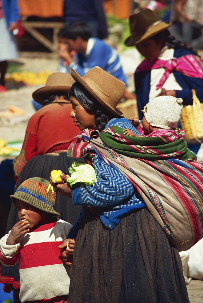 Portrait of a woman in a felt hat with her children in the Sunday market at Pisac in Peru, South America