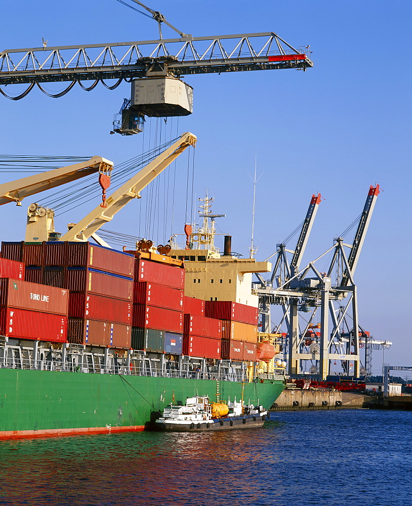 Crane lifting containers to and from cargo ship 