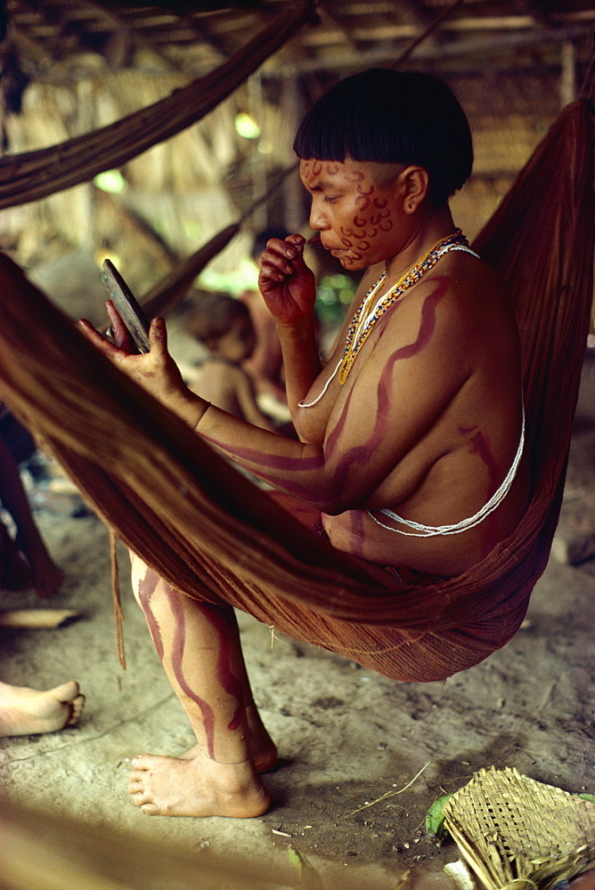 Yanomami Indian women with mirror, painting her face, Brazil, South America