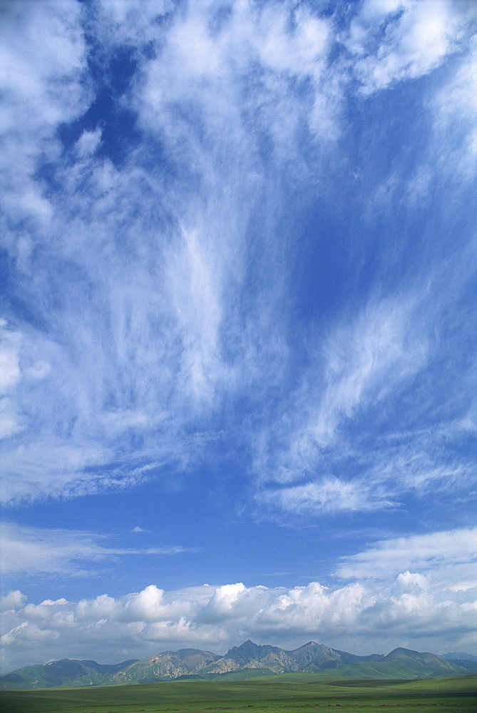 Mountains around Lake Son-Kul beneath a blue sky with white clouds in Kyrgyzstan, Central Asia, Asia