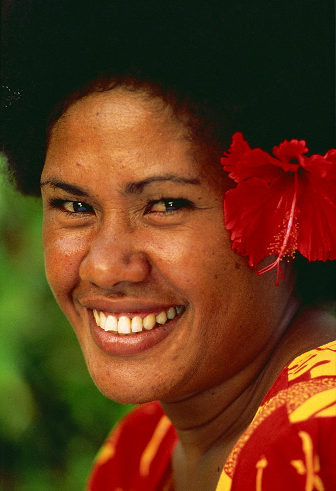 Portrait of a Melanesian girl with a red hibiscus flower in her hair on Qamea Island, Fiji, Pacific Islands, Pacific