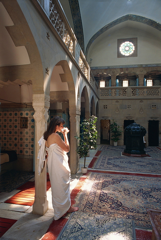 Woman drinking water in the Moorish bath house in the spa at Trenciaske Teplice, Slovakia, Europe