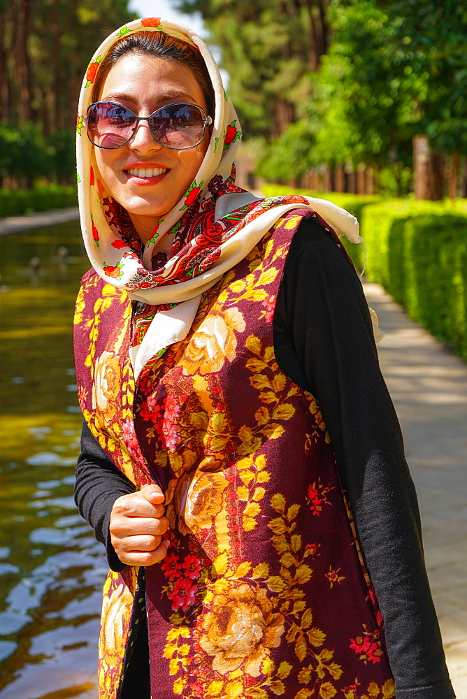 Young Iranian woman in fashionable modern clothes, Bagh-e Dolat garden, Yazd, Iran, Middle East