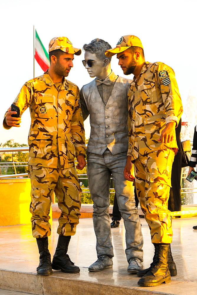 Two soldiers taking a selfie with a street performer, Tehran, Iran, Middle East