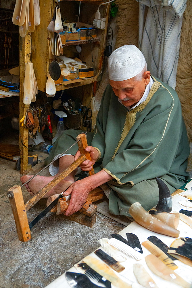 Man saws horn to make combs in an alleyway in the Old City (Medina) of Fez, UNESCO World Heritage Site, Morocco, North Africa, Africa