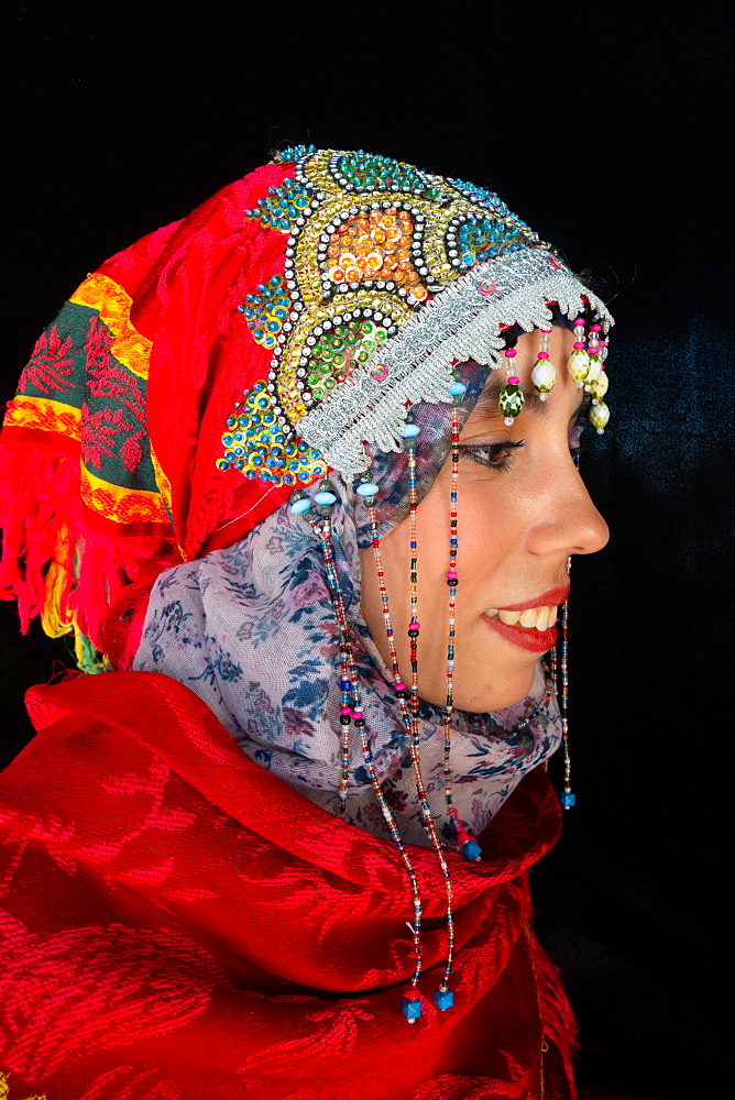 Close-up side portrait of beautiful young Moroccan woman in traditional Berber dress, in Chefchaouen, Morocco, North Africa, Africa