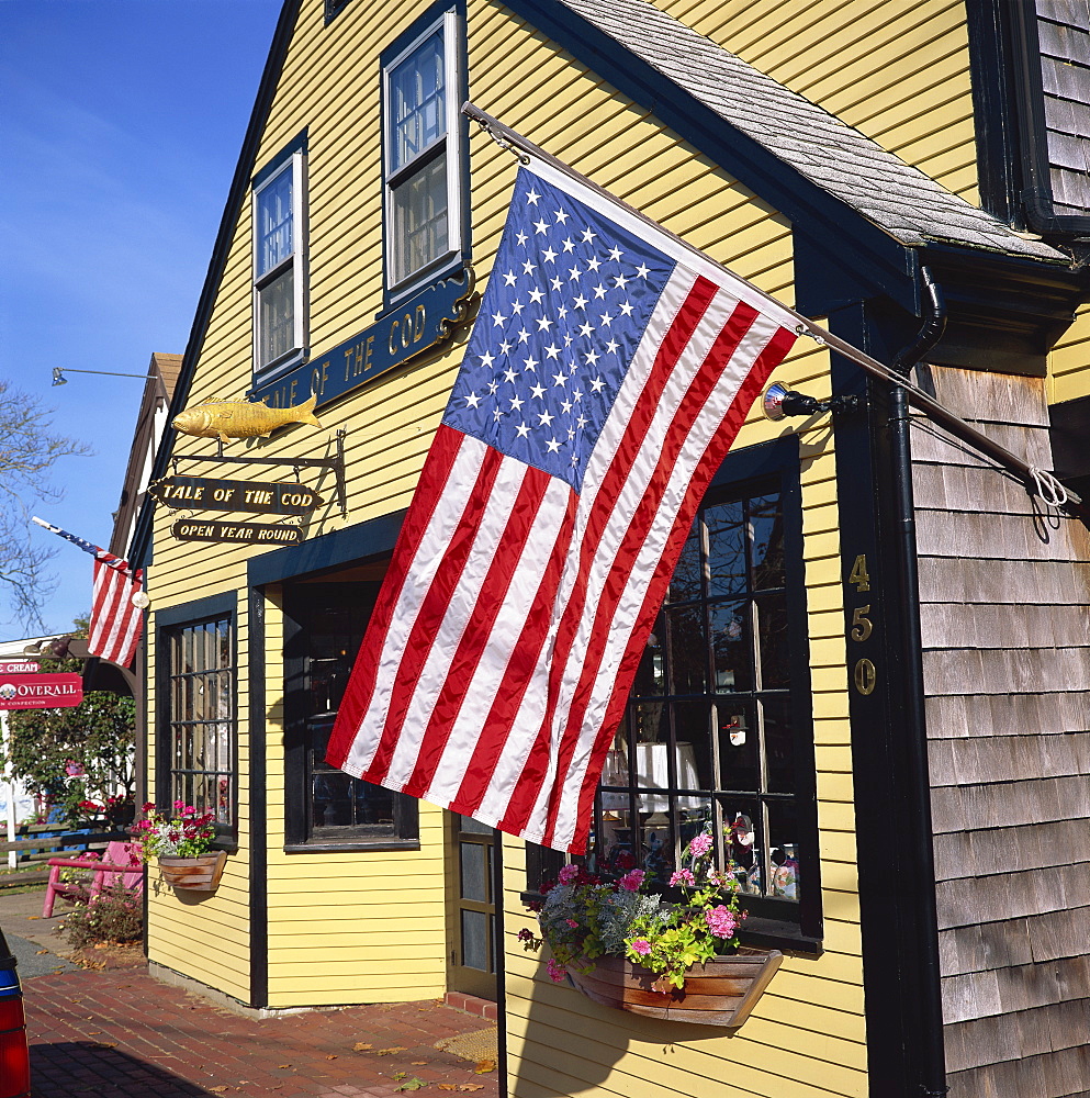 The American flag, the stars and stripes, flies outside the Tale of the Cod shop in Cape Cod, Massachusetts, New England, United States of America, North America