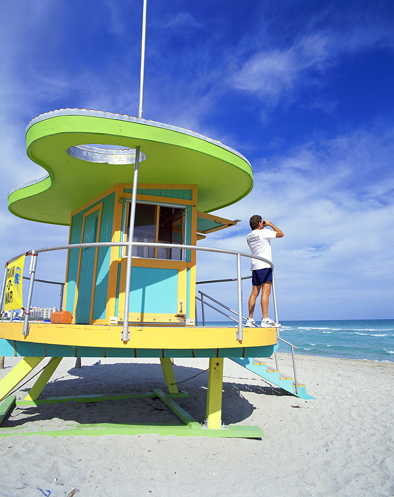 Lifeguards hut with man looking out to sea with binoculars, South Beach, Miami, Florida, United States of America, North America