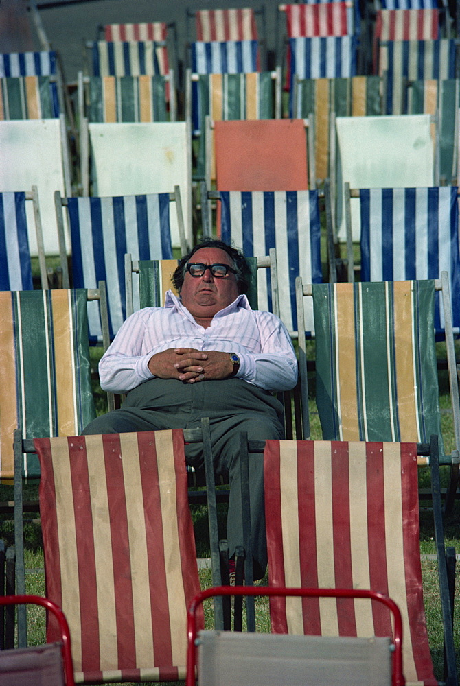 Man asleep in deck chair, England, United Kingdom, Europe