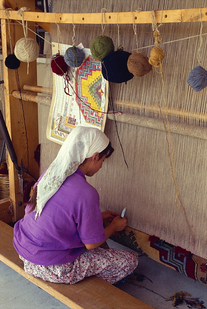 Woman weaving in a village carpet cooperative, using natural organic and vegetable dyes, at Mumcular, Anatolia, Turkey, Asia Minor, Eurasia