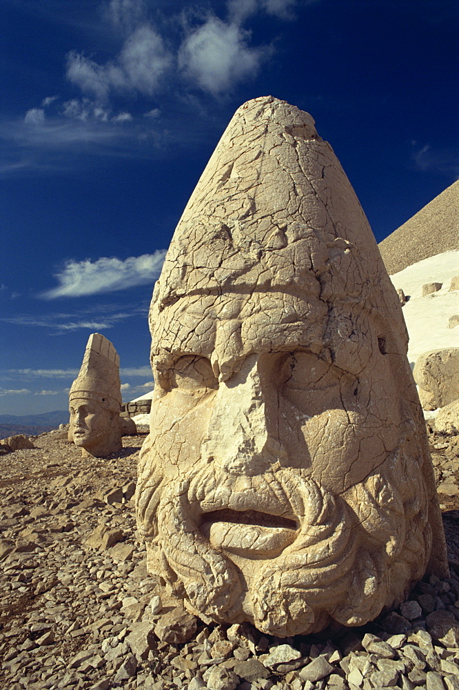 Statue head portraying Zeus, and Antiochos in background, on the west terrace at Nemrut Dag, UNESCO World Heritage Site, Anatolia, Turkey, Asia Minor, Eurasia