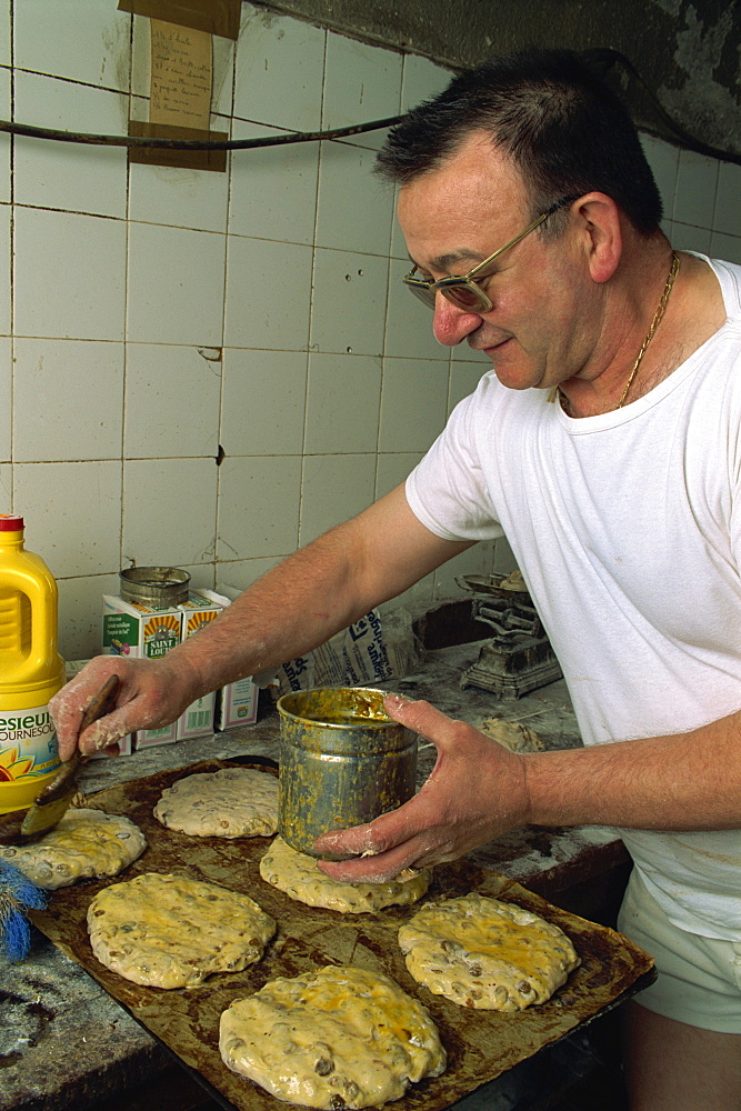 Man making Pain des Mortes, Boulangerie Faby, Bonifacio, Corsica, France, Europe