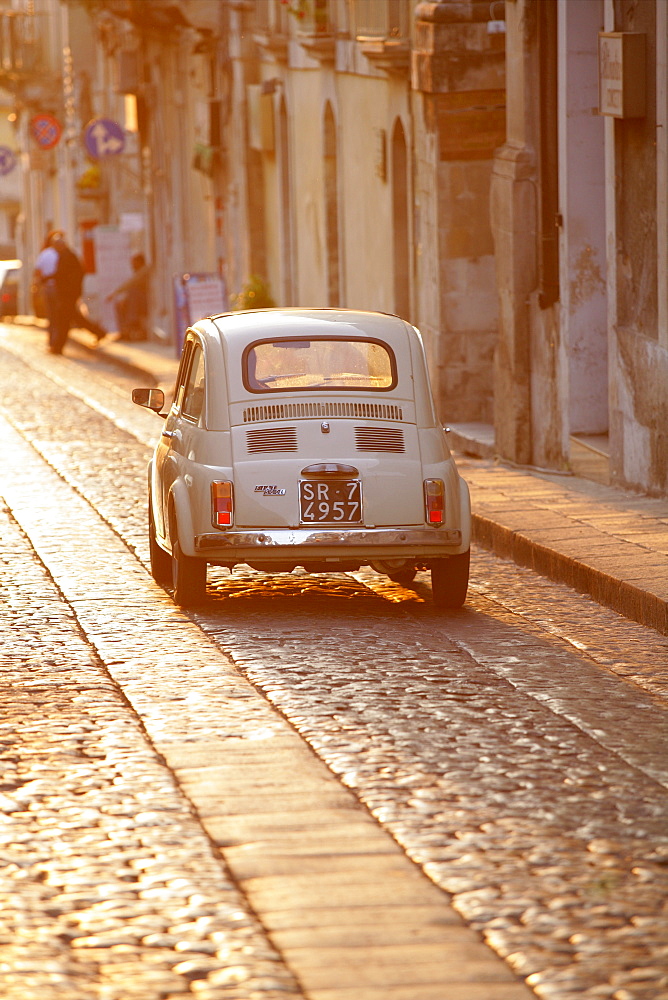 Fiat 500 driving down cobbled street, Noto, Sicily, Italy, Europe