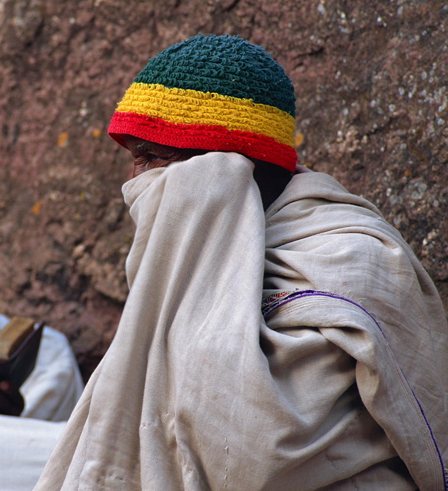 Old man in white cloth wearing hat with Ethiopian flag, Lalibela, Ethiopia, Africa