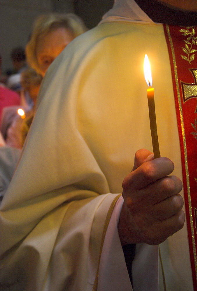 Close-up of a priest's hand holding a candle during Mass in Easter week, Church of the Holy Sepulchre, Old City, Jerusalem, Israel, Middle East