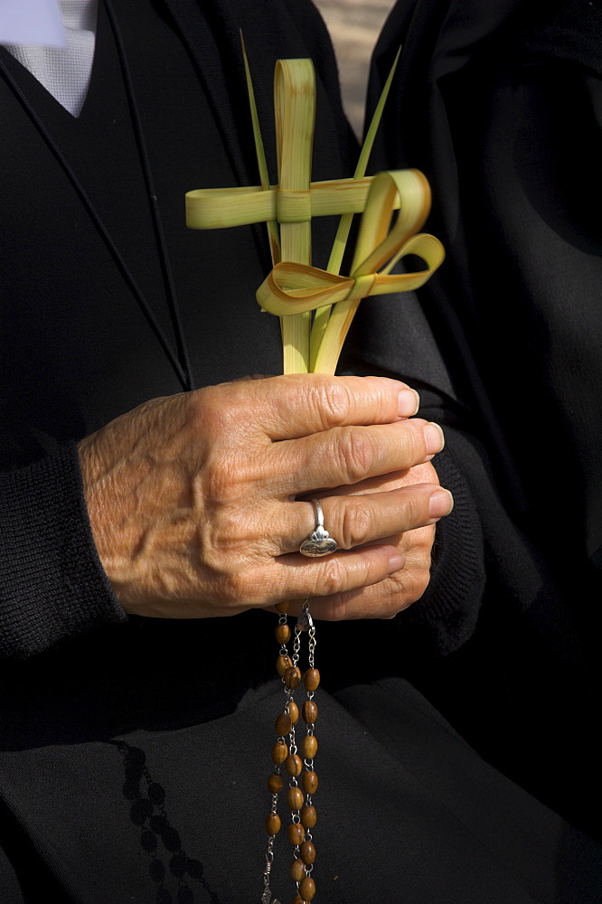 Close up of a nun's hands holding two crosses made of palm leaves, Palm Sunday Catholic Procession, St. Anne church, Jerusalem, Israel, Middle East