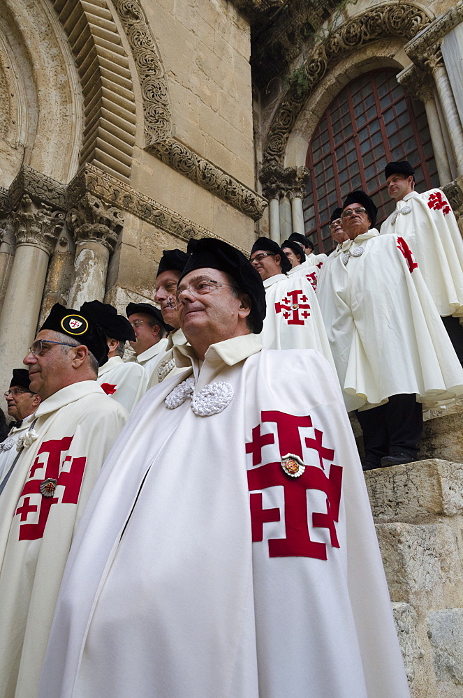 Members of the Order of the Holy Sepulchre pausing in full dress at the Holy Sepulchre, Jerusalem Old City, Israel, Middle East