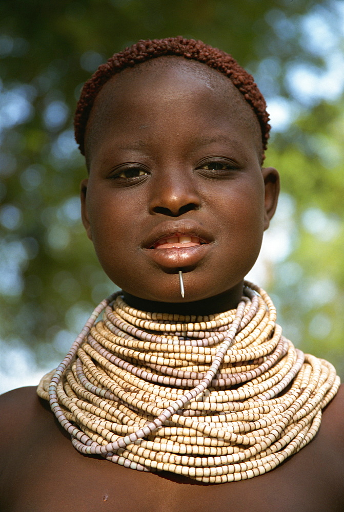 Young girl with henna in hair and wearing beads and nail, Omo camp, Murulle, Ethiopia, Africa