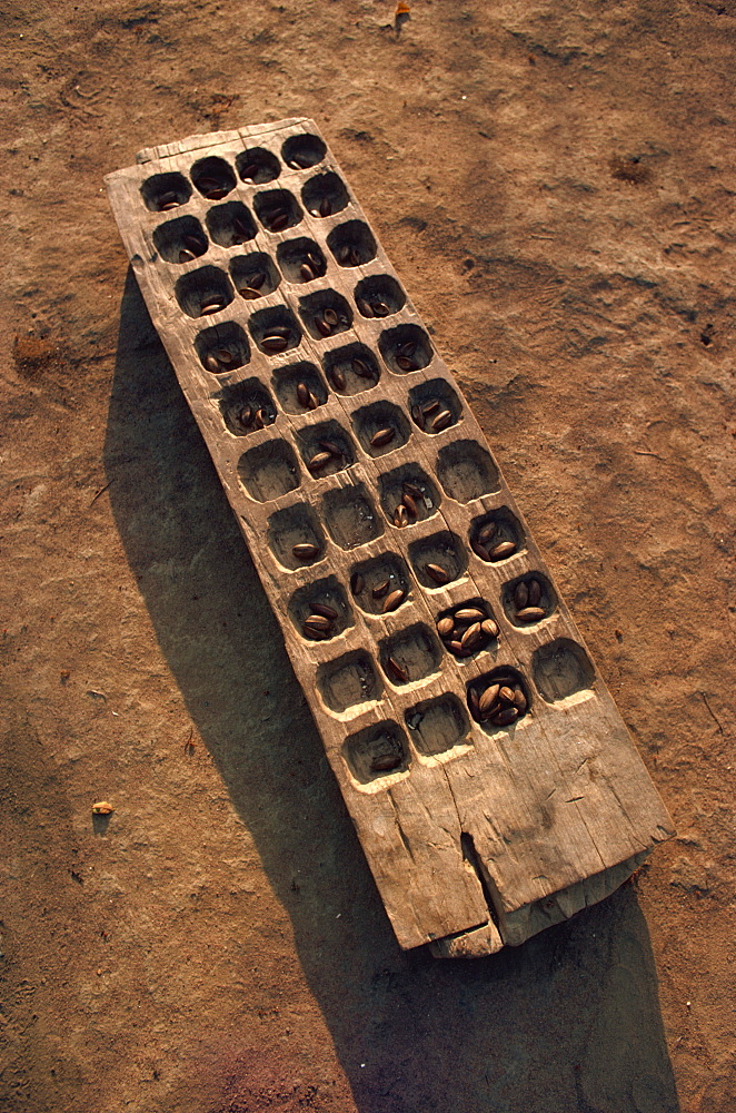 Wooden gaming board (houri) and dried beads, Maridi village, Sudan, Africa