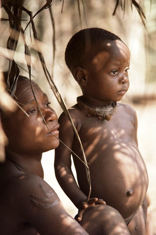 Pygmy woman and child in entrance to hut, near Lobaye River, Central African Republic, Africa