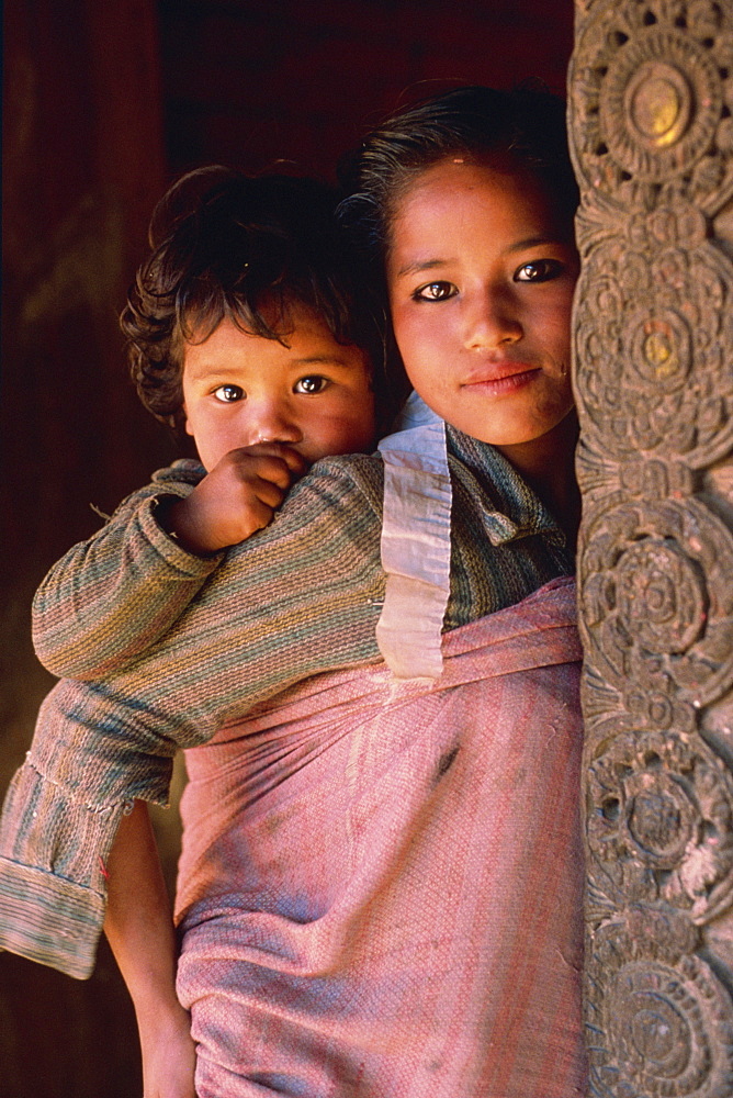 Portrait of young mother and baby, looking at the camera, Bhaktapur, Nepal, Asia